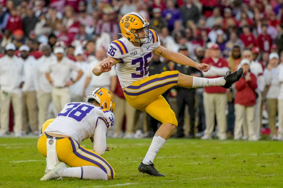 FILE - LSU kicker Cade York (36) kicks an extra point with punter Zach Von Rosenberg (38) holdi ...