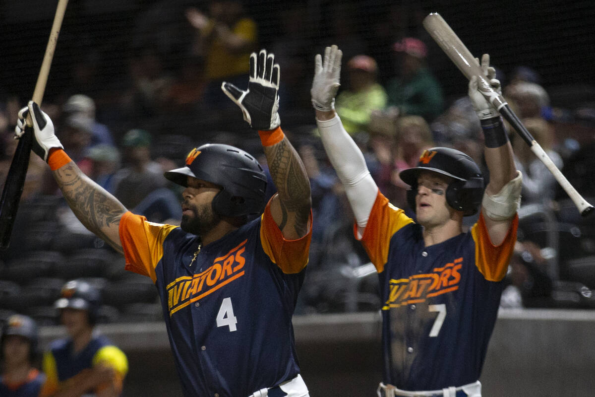 Las Vegas Aviators infielders Eric Thames (4) and Marty Bechina (7) cheer as their teammates re ...