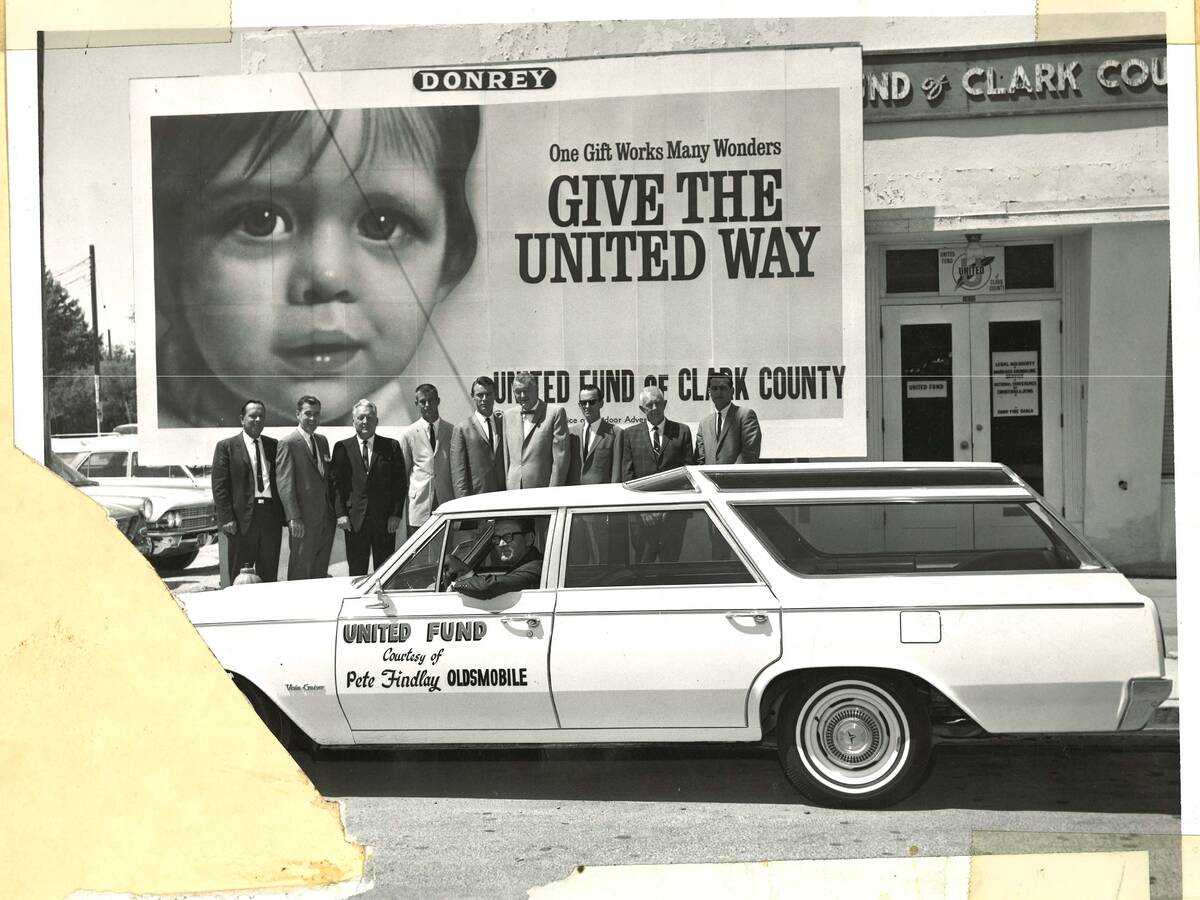 People pose for a photo outside the United Fund of Clark County office with a United Fund car, ...