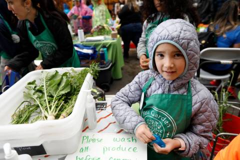 Skylar Schill, 8, second grader of Bass Elementary School, sells vegetables at their booth, Fri ...