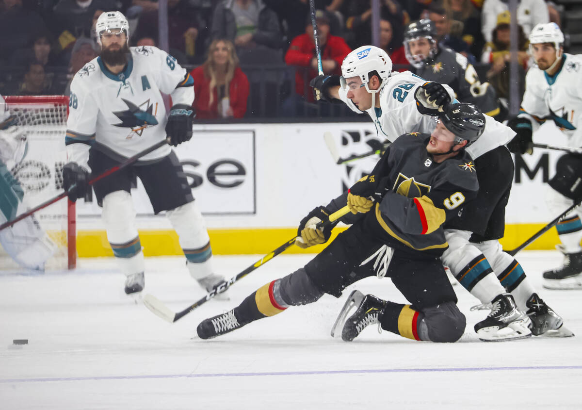 Golden Knights center Jack Eichel (9) gets tripped up by San Jose Sharks right wing Timo Meier ...