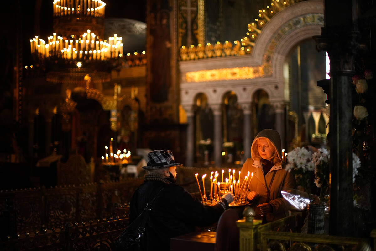 Worshippers light candles at the Saint Volodymyr's Cathedral during Orthodox Eastern celebratio ...