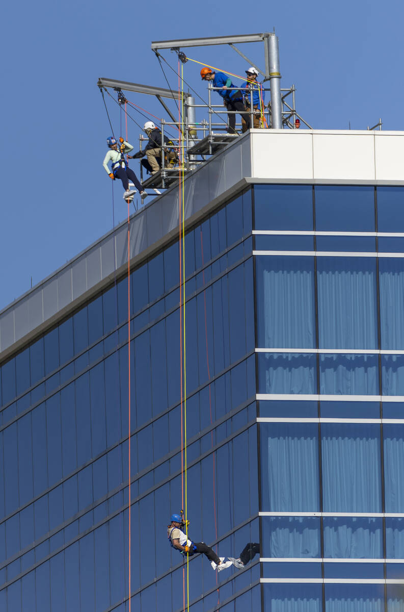 Rappellers begin to work their way from the roof at the Opal Tower at Virgin Hotels Las Vegas a ...