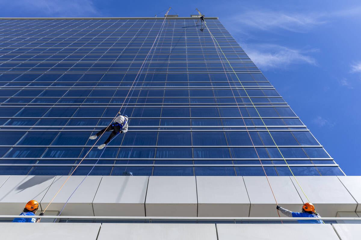 Rappellers begin to work their down from the roof at the Opal Tower at Virgin Hotels Las Vegas ...