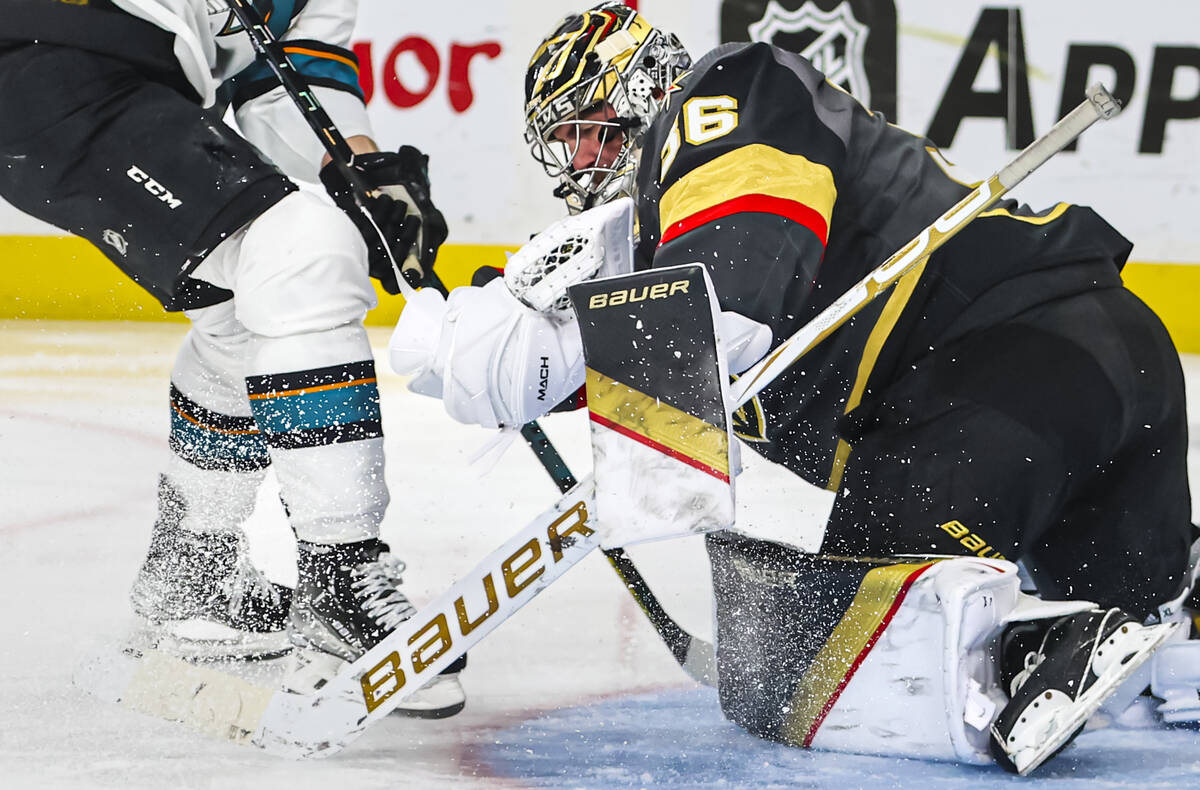 Golden Knights goaltender Logan Thompson (36) stops the puck in front of San Jose Sharks right ...