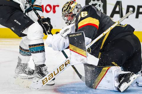Golden Knights goaltender Logan Thompson (36) stops the puck in front of San Jose Sharks right ...