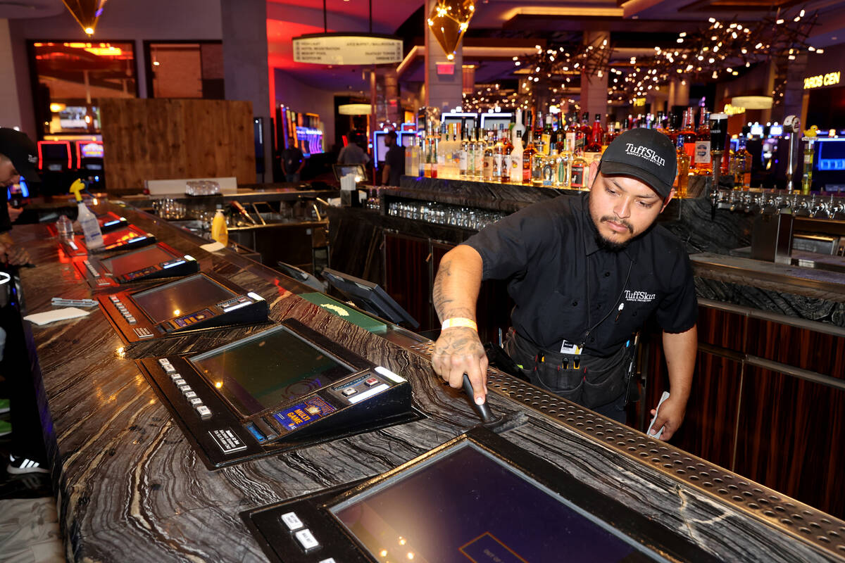 Daniel Martinez of TuffSkin removes an old bar surface protection before installing a new one a ...