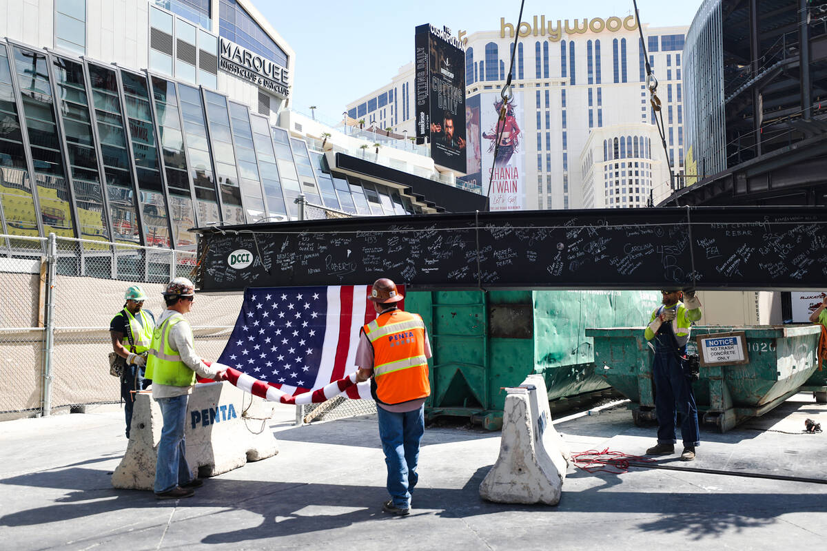 Workers ready the last beam to be hoisted onto the building at the topping off ceremony for Pro ...