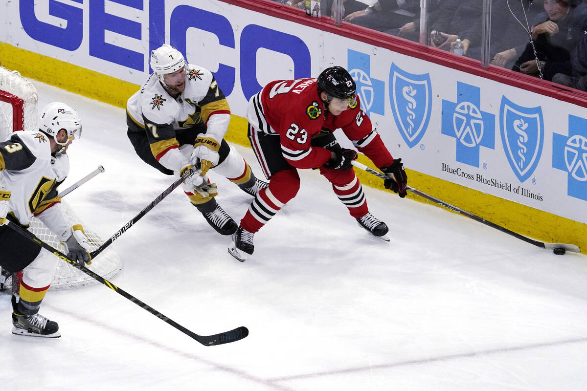 Chicago Blackhawks center Philipp Kurashev, right, controls the puck against Vegas Golden Knigh ...