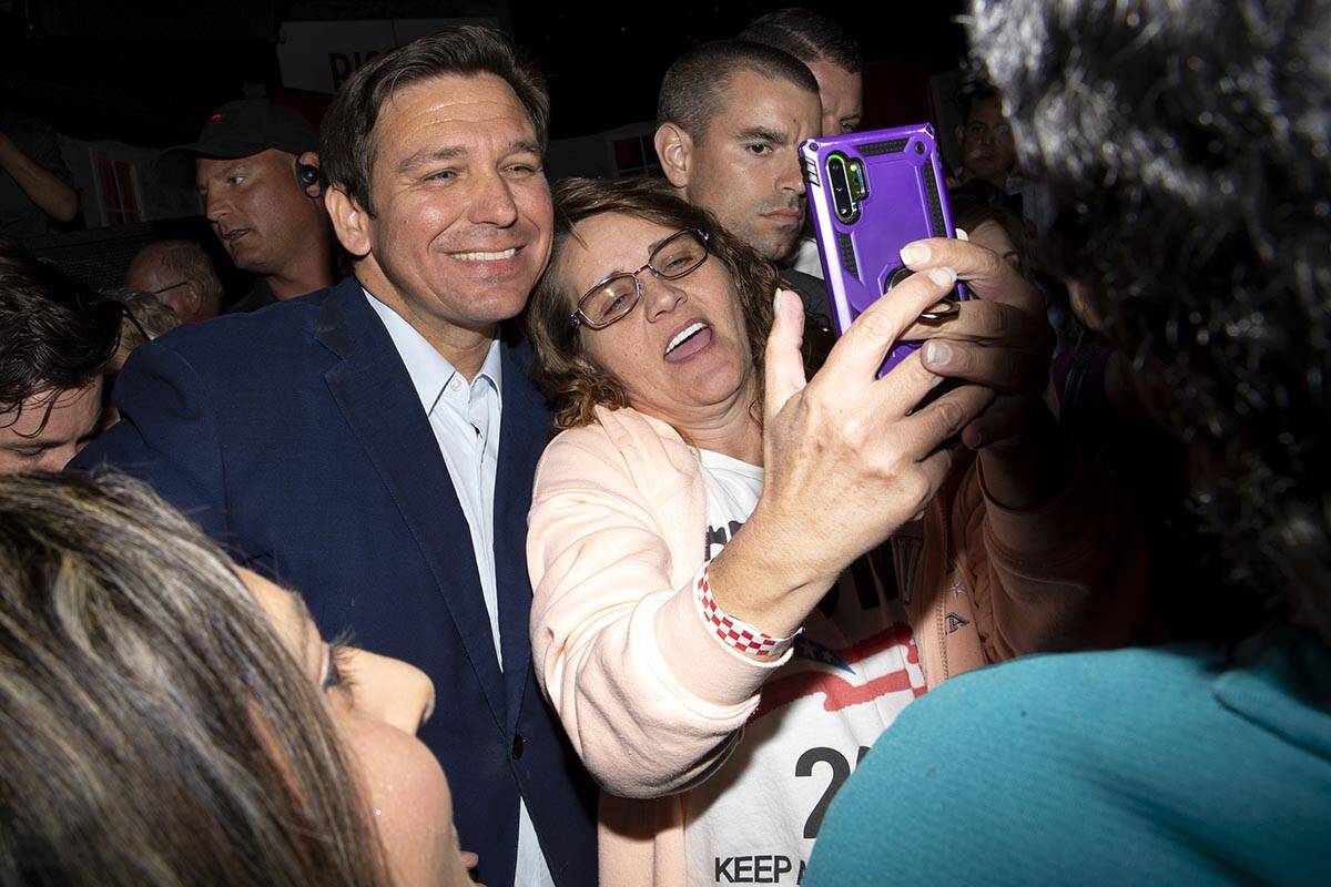Florida Gov. Ron DeSantis poses for photos with an attendee during a rally for Nevada Republica ...
