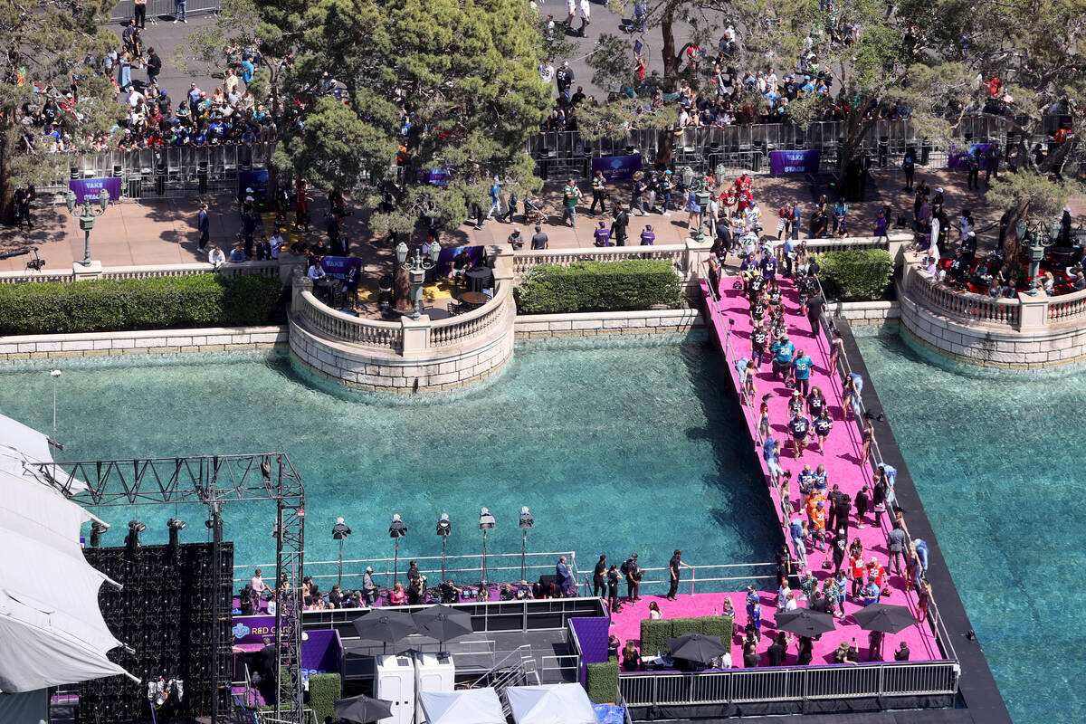 Fans watch the red carpet from the closed Strip on the fountains of the Bellagio in Las Vegas T ...