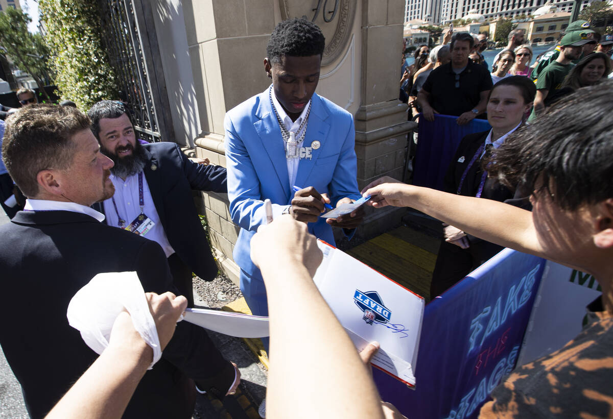 NFL draft prospect Ahmad "Sauce" Gardner signs items for fans during the first day of ...
