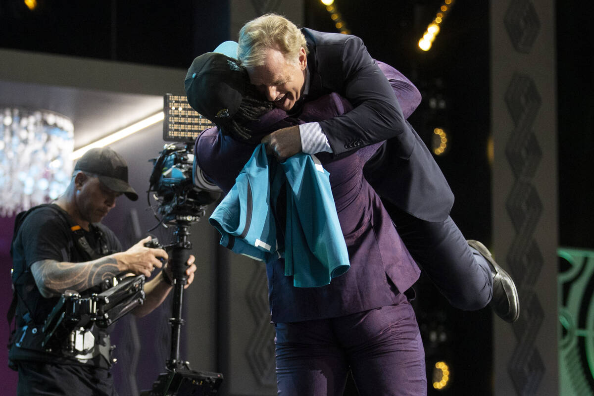 Utah linebacker Devin Lloyd lifts NFL Commissioner Roger Goodell after being chosen by the Jack ...