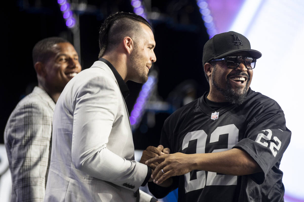 Ice Cube, right, shakes hands with Raiders quarterback Derek Carr on stage during the NFL Draft ...