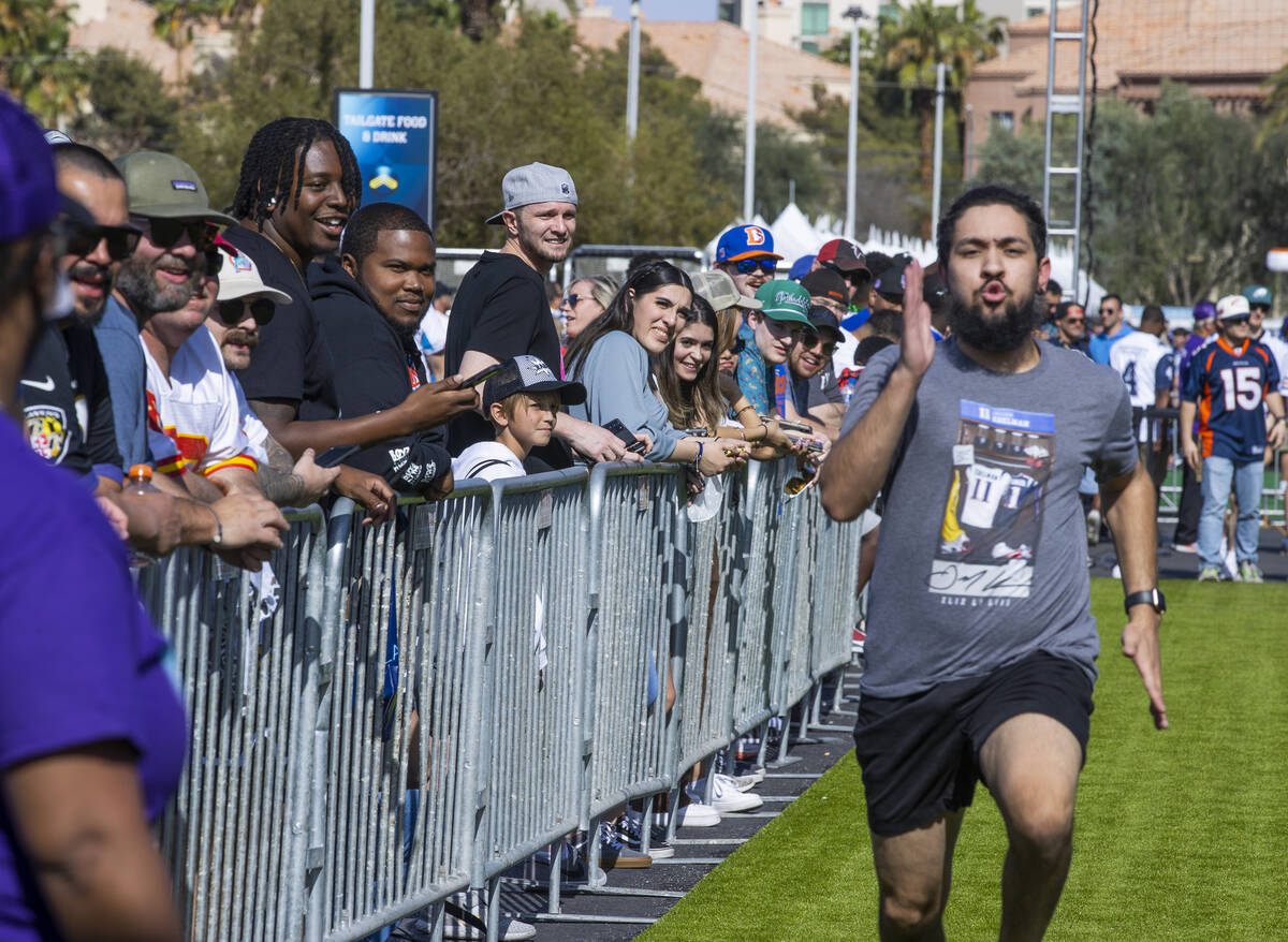 Fans look on as another runs a 40-yard dash within the Draft Experience on the first day events ...