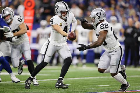 Raiders quarterback Derek Carr (4) hands off the ball to running back Josh Jacobs (28) in the f ...