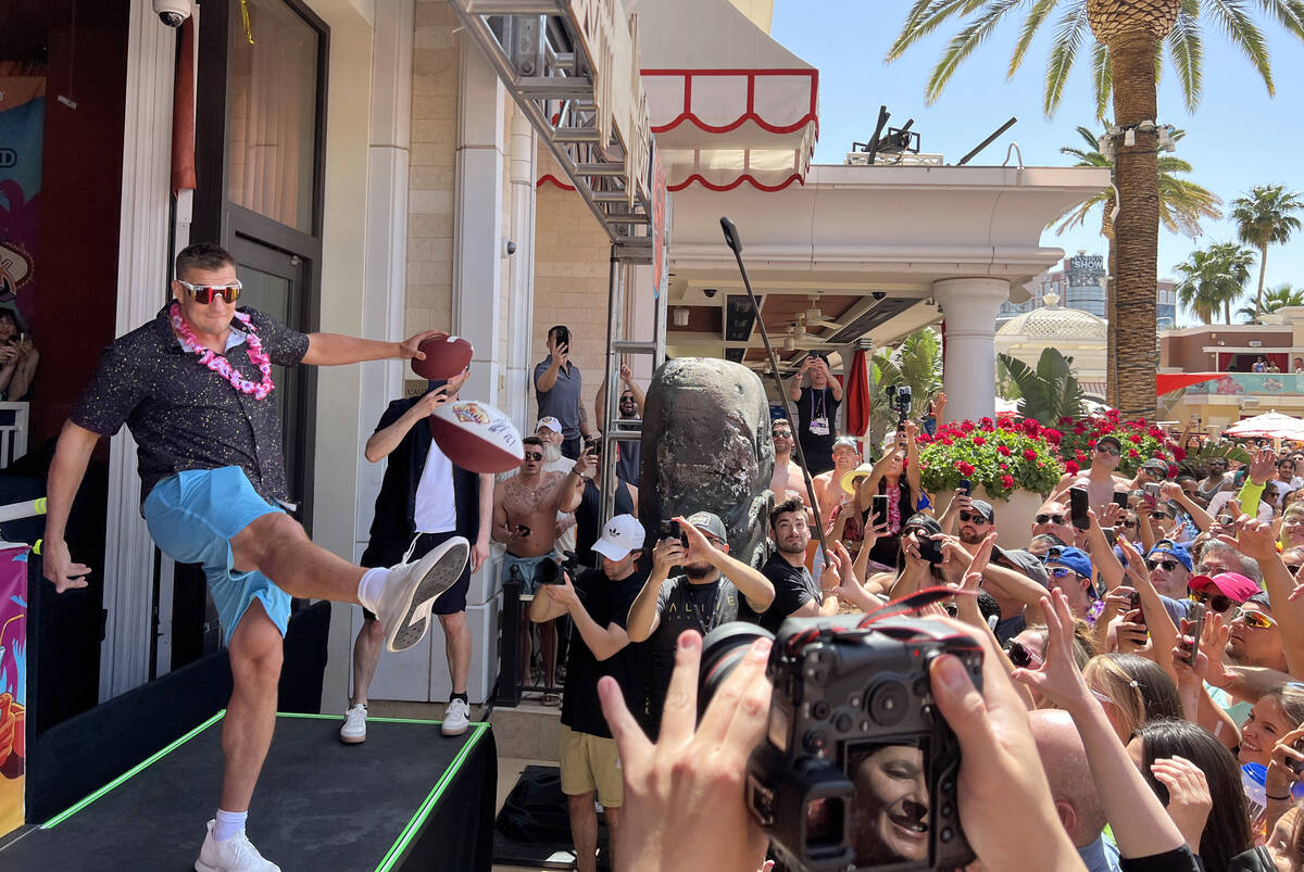 Rob Gronkowski kicks a signed football during Gronk Beach party at Encore Beach Club on the Str ...