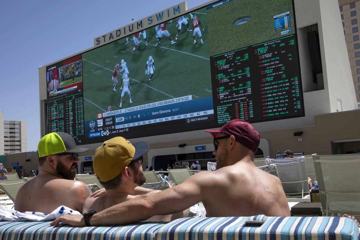 Pool guests watch NFL football draft coverage on the screen in Stadium Swim at Circa, Friday, A ...