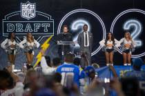 Wayne Newton stands on the stage with retired professional football player Marcus Allen to anno ...