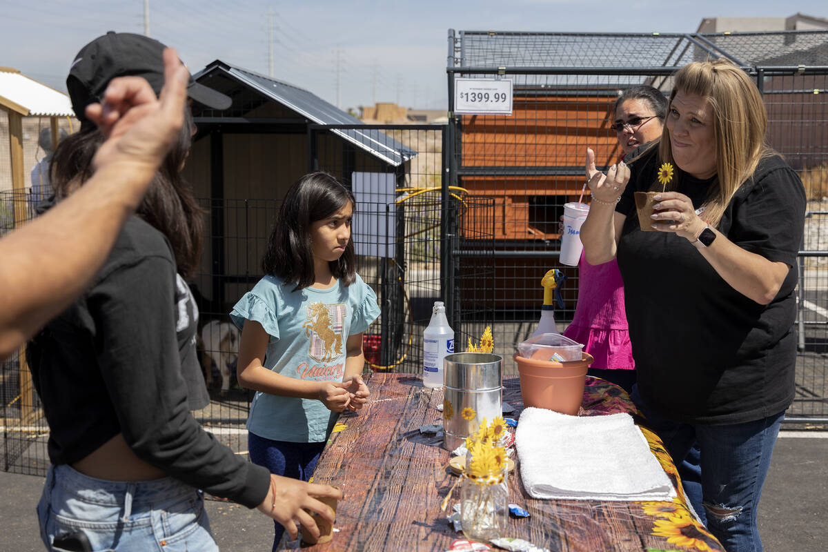 Holly Kirk, right, manager at Tractor Supply Company, shows attendees of a gardening expo how t ...