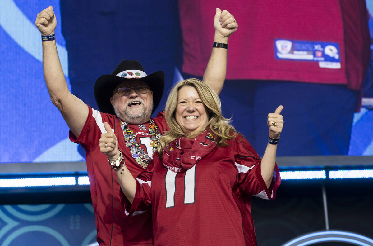 Rick and Lisa Wilcoxson, from Phoenix, Ariz, celebrate after learning they received tickets to ...