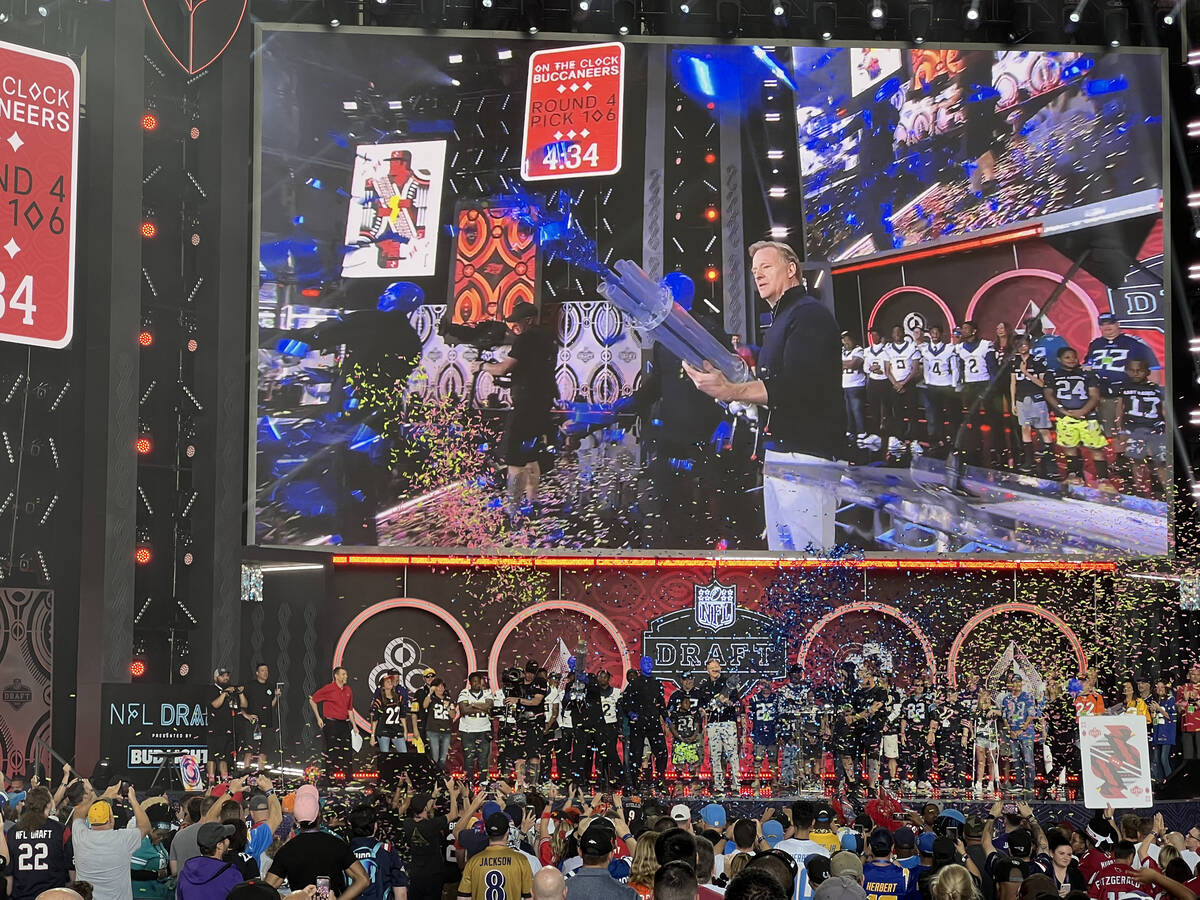 NFL Commissioner Roger Goodell shoots a confetti gun with the Blue Man Group on the main stage ...