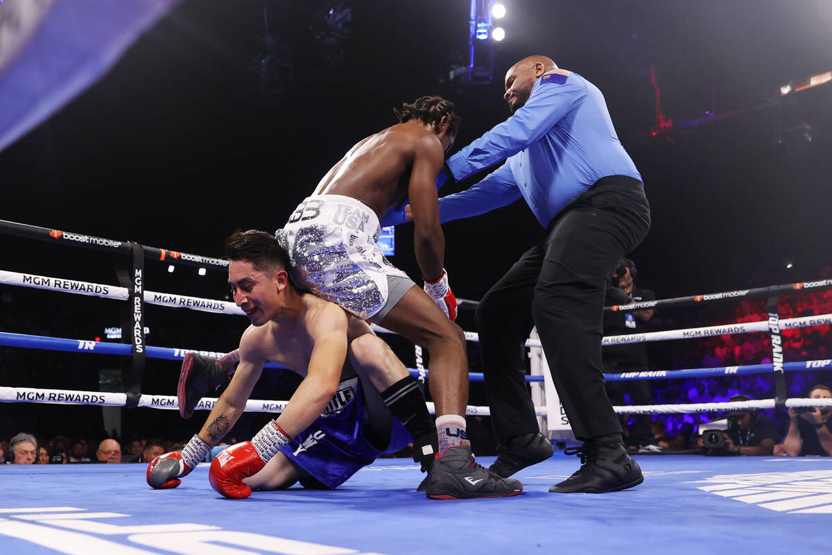 Keyshawn Davis, right, walks over Esteban Sanchez in the third round of a lightweight fight at ...