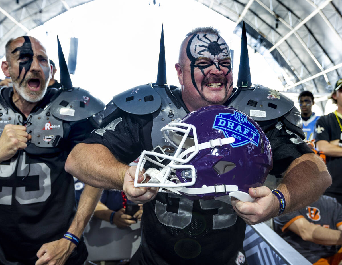 A Raiders fan shows off the 2022 NFL draft helmet he just won in a trivia contest in the Draft ...