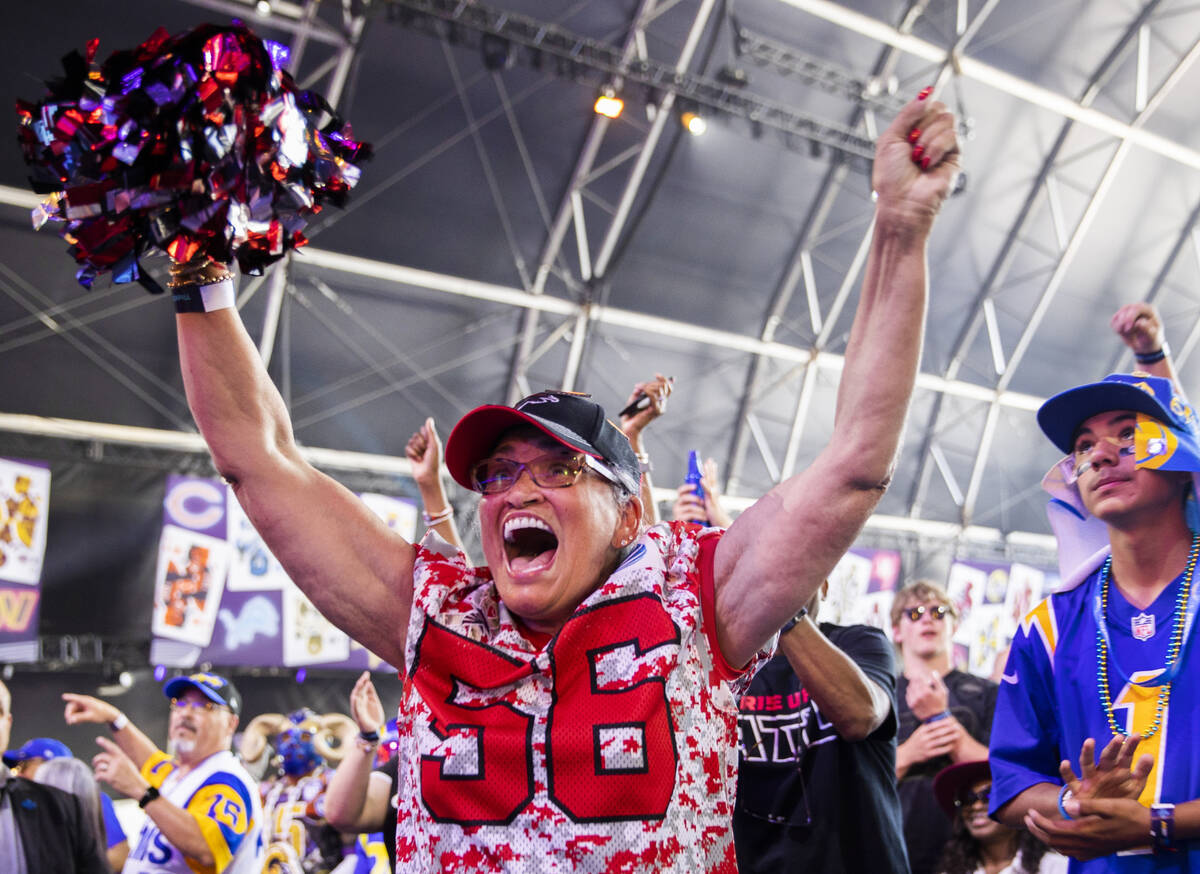 Lizzette Strickland, from Atlanta, Ga., celebrates after winning an autographed football after ...