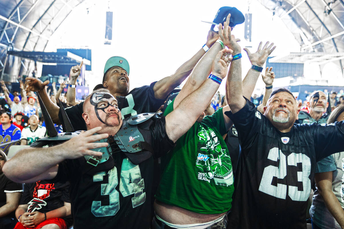 Raiders fans fight for a baseball hat with a Jets fan during day three of the NFL draft on Satu ...
