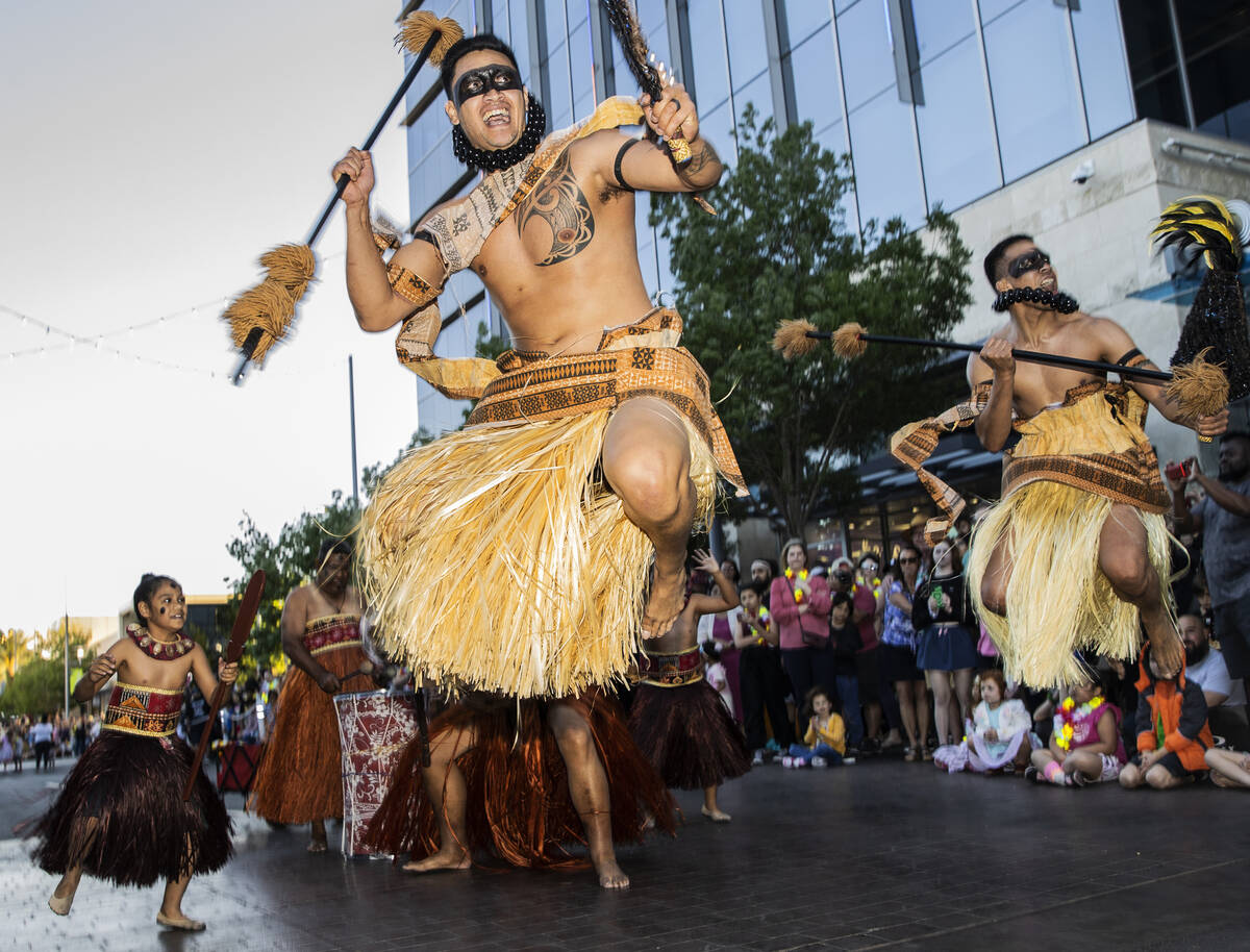 Naenoa George, front/left, leaps in the air while performing during Lei Day, a new parade to ce ...