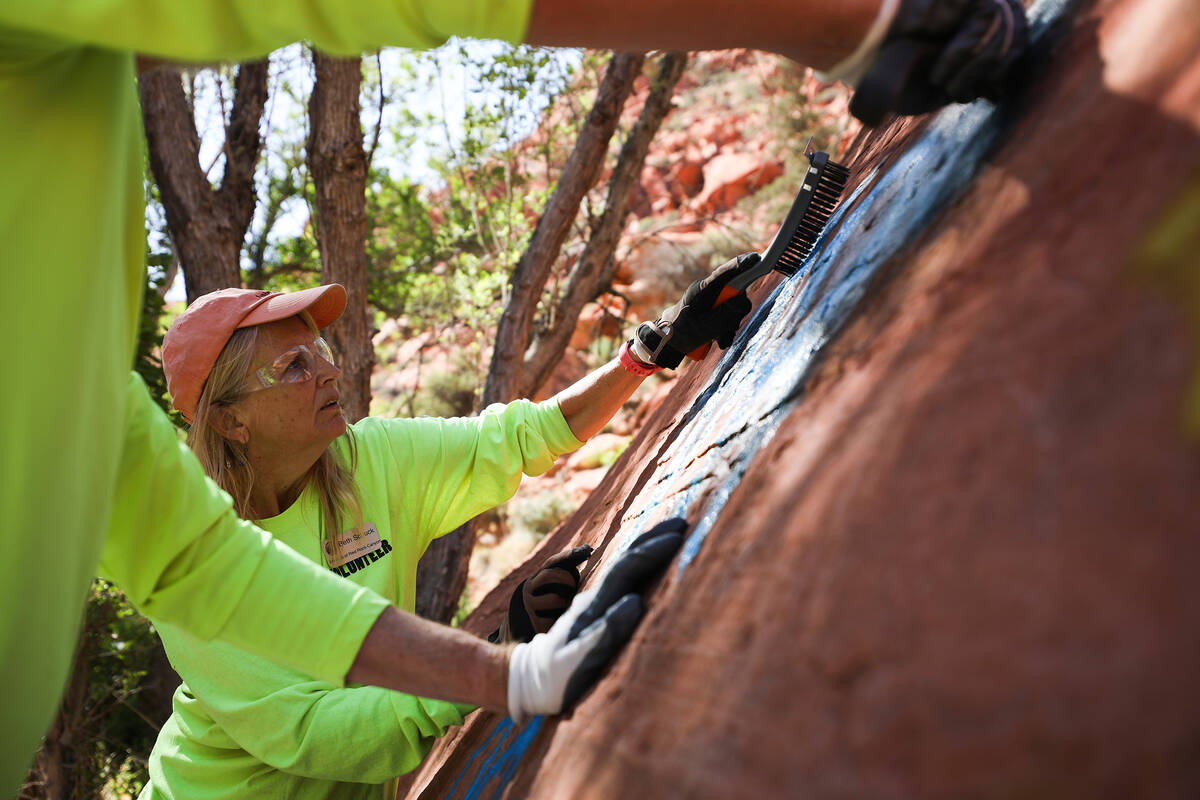 Volunteer Beth Schuck works to remove graffiti along Ash Springs trail in Red Rock Canyon in La ...