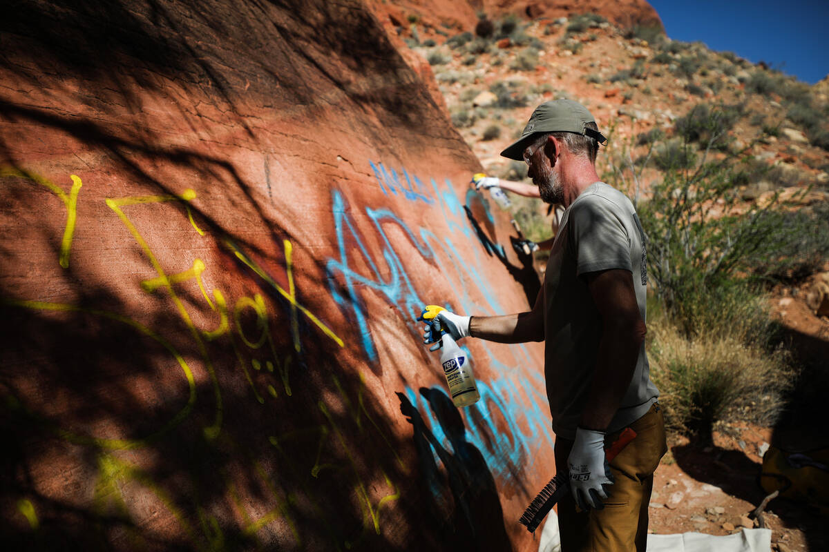 Volunteer Rick Momsen works to remove graffiti along Ash Springs trail in Red Rock Canyon in La ...
