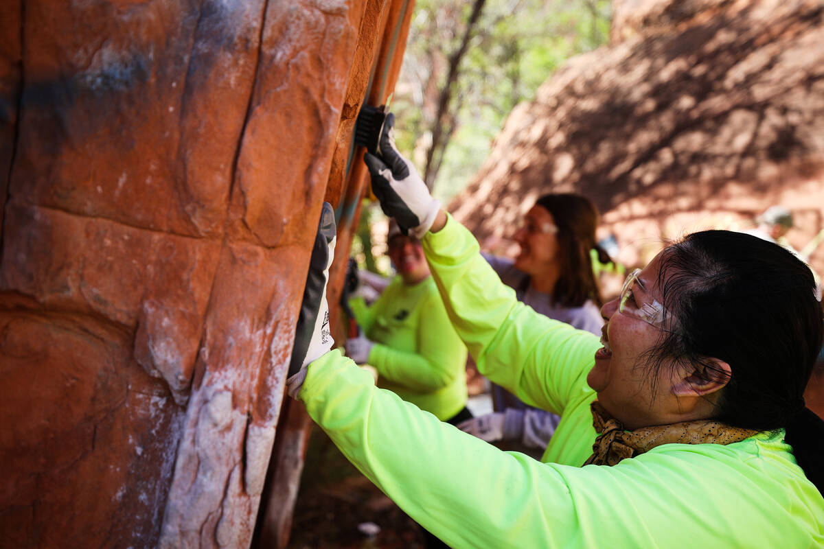 Volunteer Sharon Gross works to remove graffiti along Ash Springs trail in Red Rock Canyon in L ...
