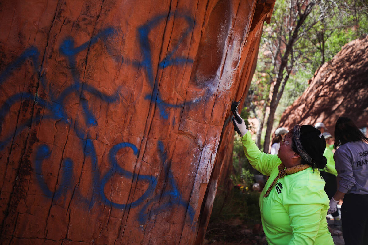 Volunteer Sharon Gross works to remove graffiti along Ash Springs trail in Red Rock Canyon in L ...