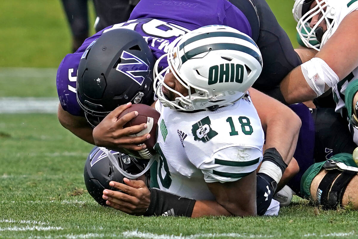 Ohio quarterback Armani Rogers (18) is sacked by Northwestern defensive lineman Sean McLaughlin ...