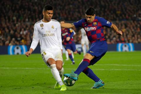 Barcelona's Luis Suarez, right, vies for the ball with Real Madrid's Casemiro during a Spanish ...