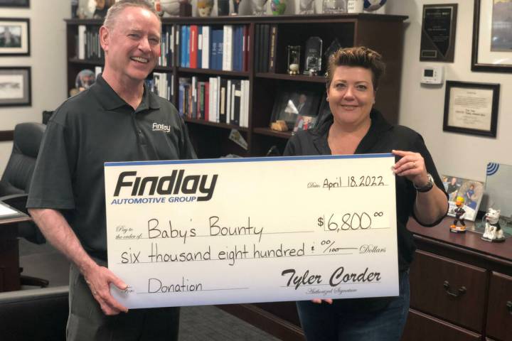 Findlay Findlay’s Tyler Corder presents a check to Kelly Maxwell, Baby’s Bounty’s executi ...