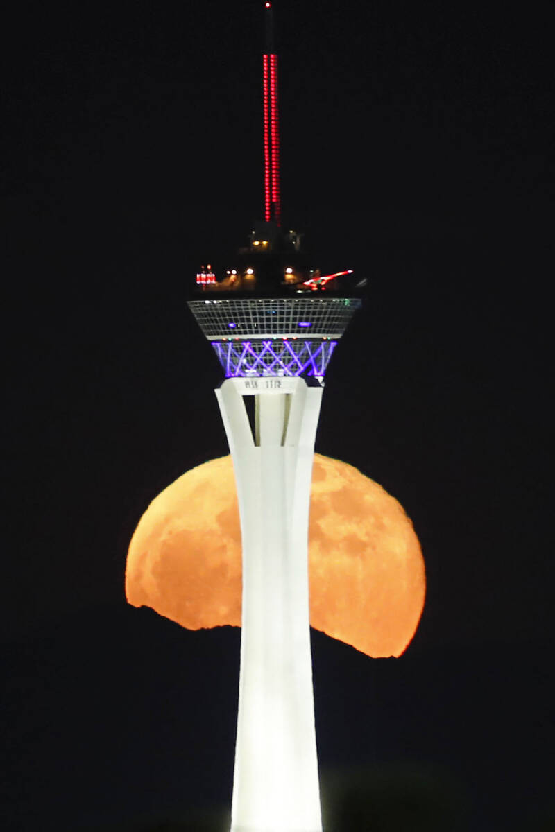 The moon rises behind The Strat in Las Vegas, Wednesday, May 26, 2021. (Chitose Suzuki / Las Ve ...