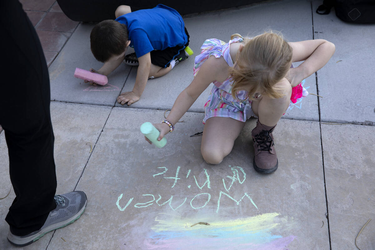 Opal May-Spencer, 7, writes “women rights” on the cement during a rally in suppor ...