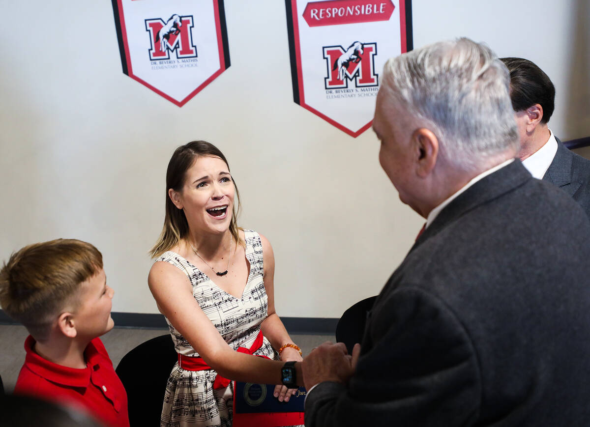 Music teacher Ali Jun, left, shakes hands with Gov. Steve Sisolak, right, after she won the Mil ...