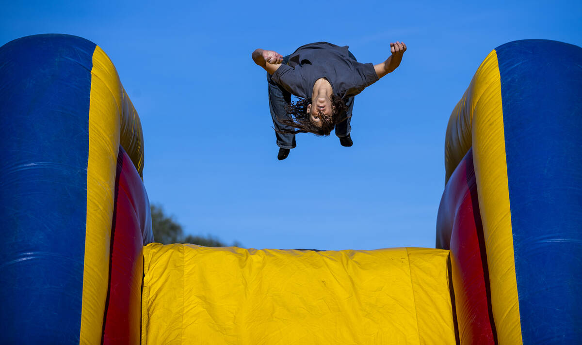 Raymond Sepulveda, 15, does a backflip off a bouncy slide as part of a celebration of life for ...