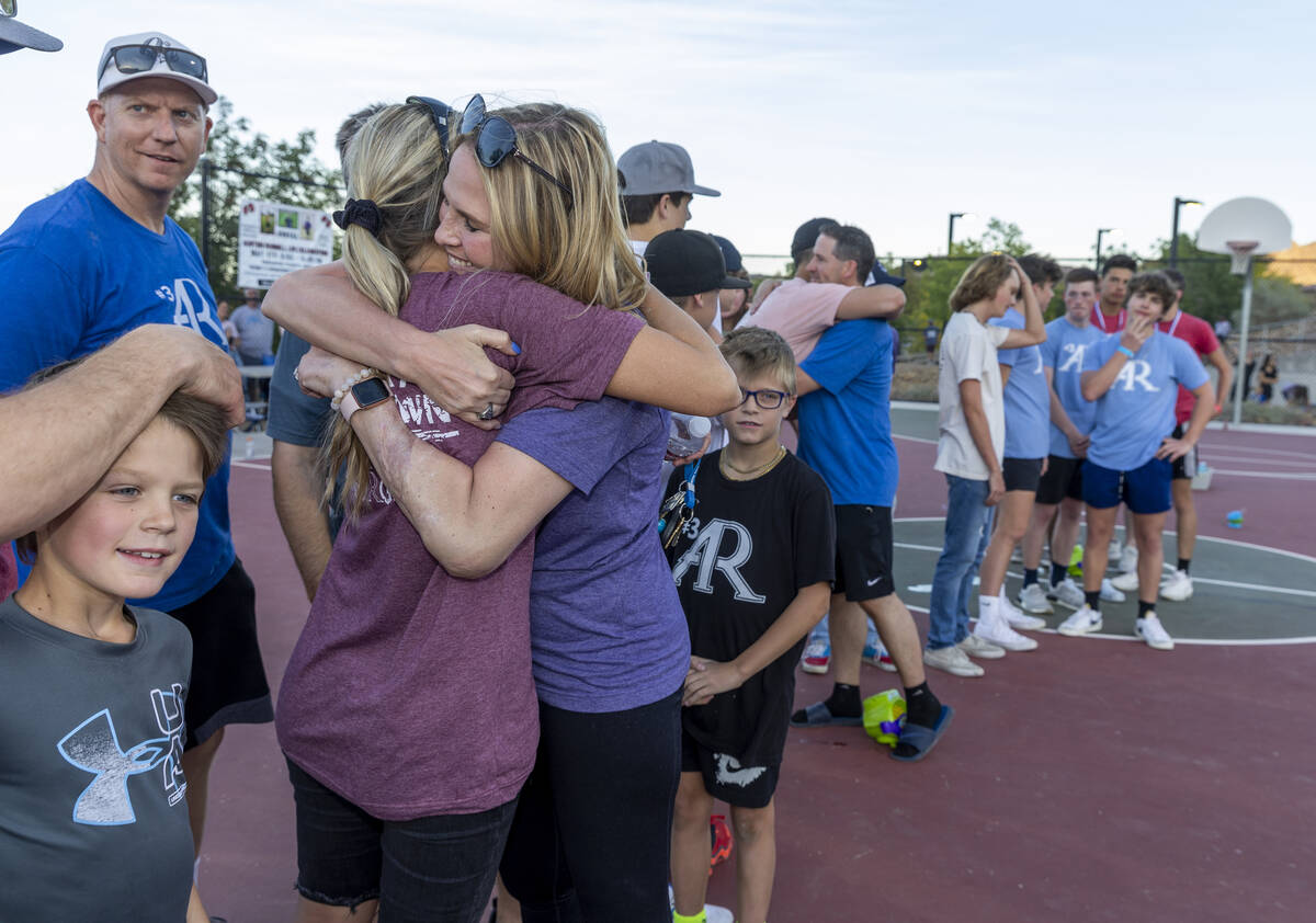 Deedra Russell, center, and Troy Russell, right center, get hugs from friends during a celebrat ...