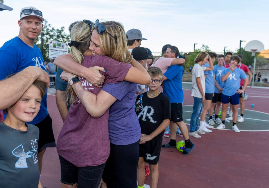 Deedra Russell, center, and Troy Russell, right center, get hugs from friends during a celebrat ...