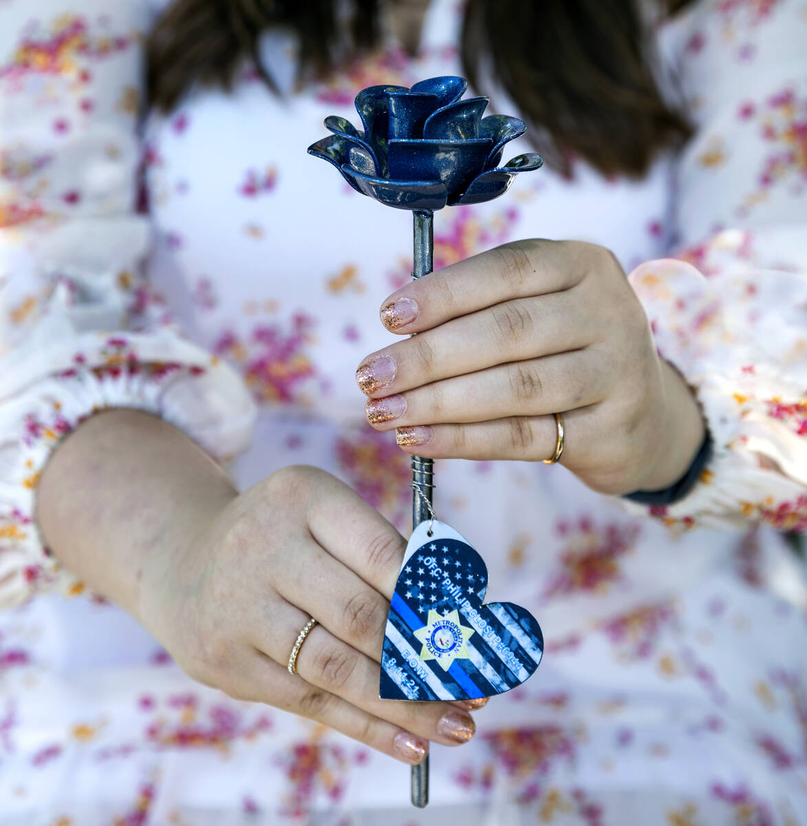Nicola Closi, 17, holds memorial blue rose in honor of her father, Las Vegas police officer Phi ...