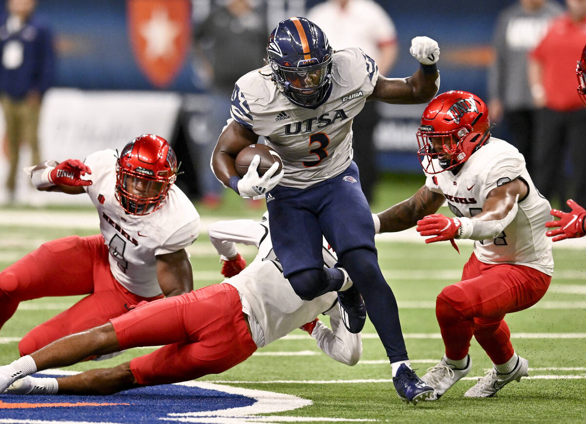 UTSA's Sincere McCormick (3) attempts to evade UNLV's Bryce Jackson, right, Jacoby Windmon, lef ...