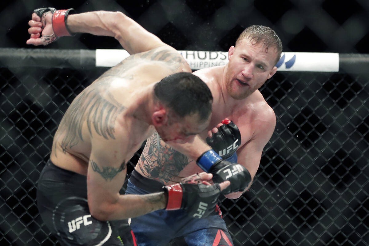 Tony Ferguson, left, falls backward after taking a punch from Justin Gaethje during a UFC 249 m ...