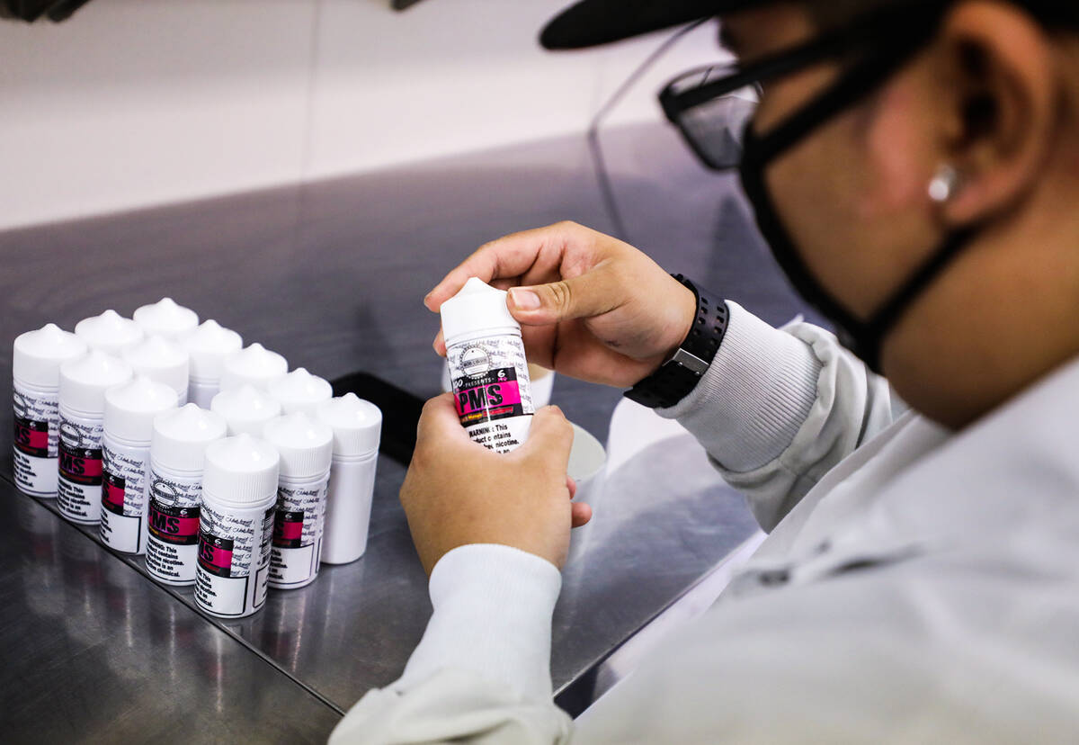 Elijah Otoman fulfills an order of e-liquids at Mob Liquid Labs in Las Vegas, Thursday, May 12, ...