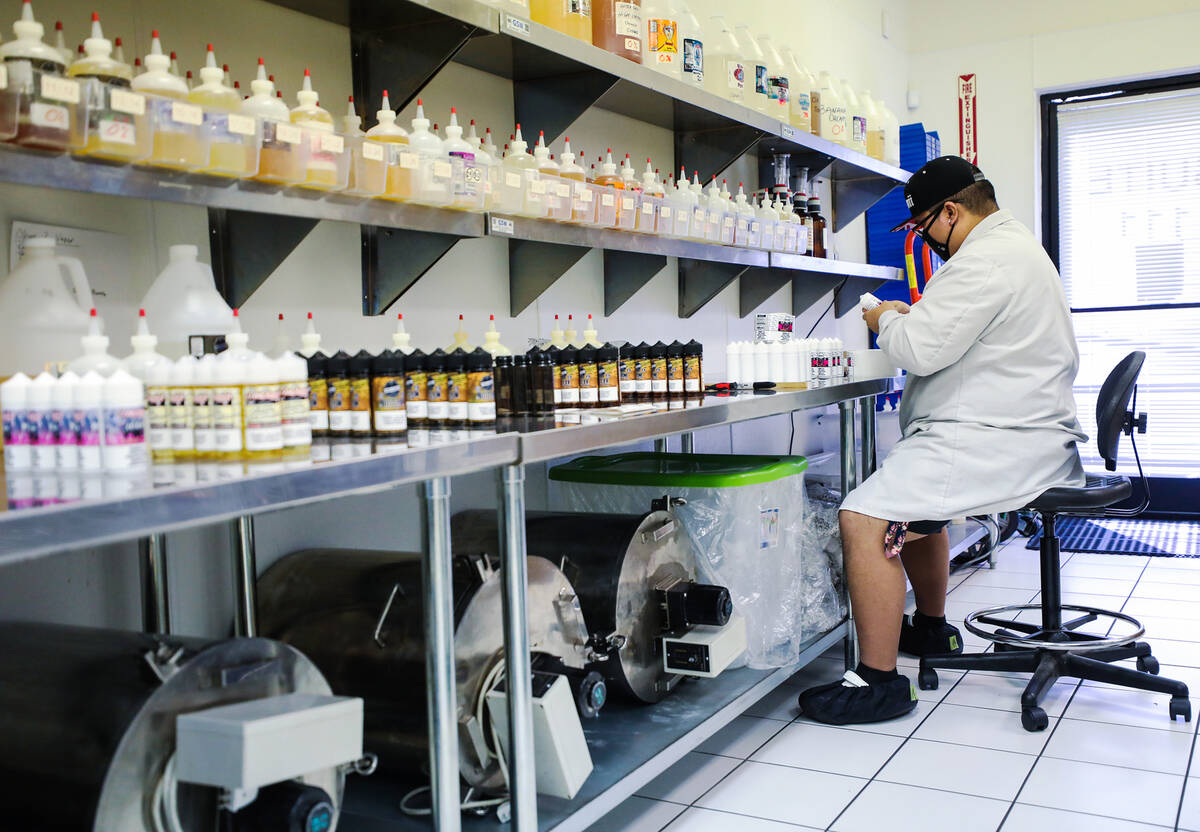 Elijah Otoman fulfills an order of e-liquids at Mob Liquid Labs in Las Vegas, Thursday, May 12, ...
