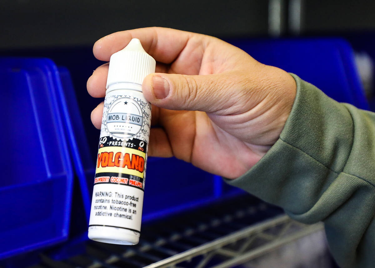 Owner Alex Mazzola holds a flavor of e-liquid he manufactures at Mob Liquid Labs in Las Vegas, ...